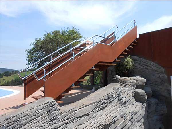 La escalera se fusiona con la fachada del edifico, en acero corten escaleras exteriores en deba orio zumaia mutriku zarautz