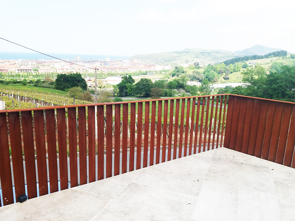 barandillas exteriores de acero corten con pletinas de pasamanos y postes verticales