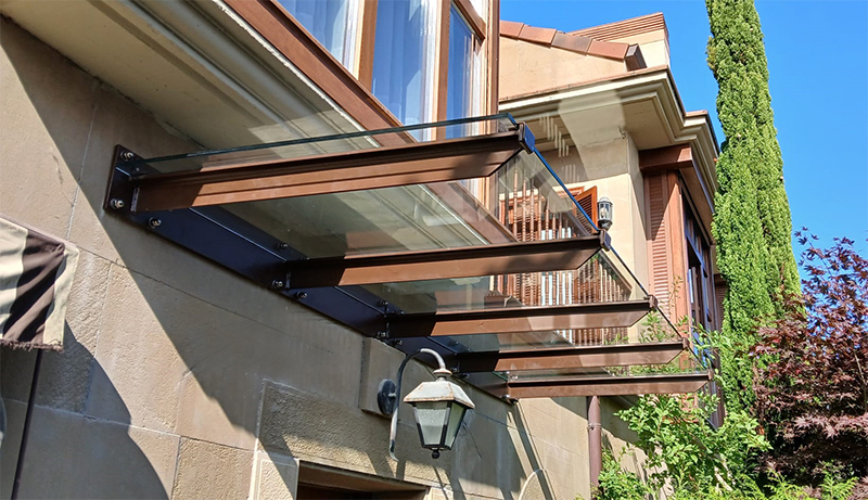 marquesina tipo aterpe para proteccion de la lluvia en vivienda de donostia san sebastian en marron ral 8028